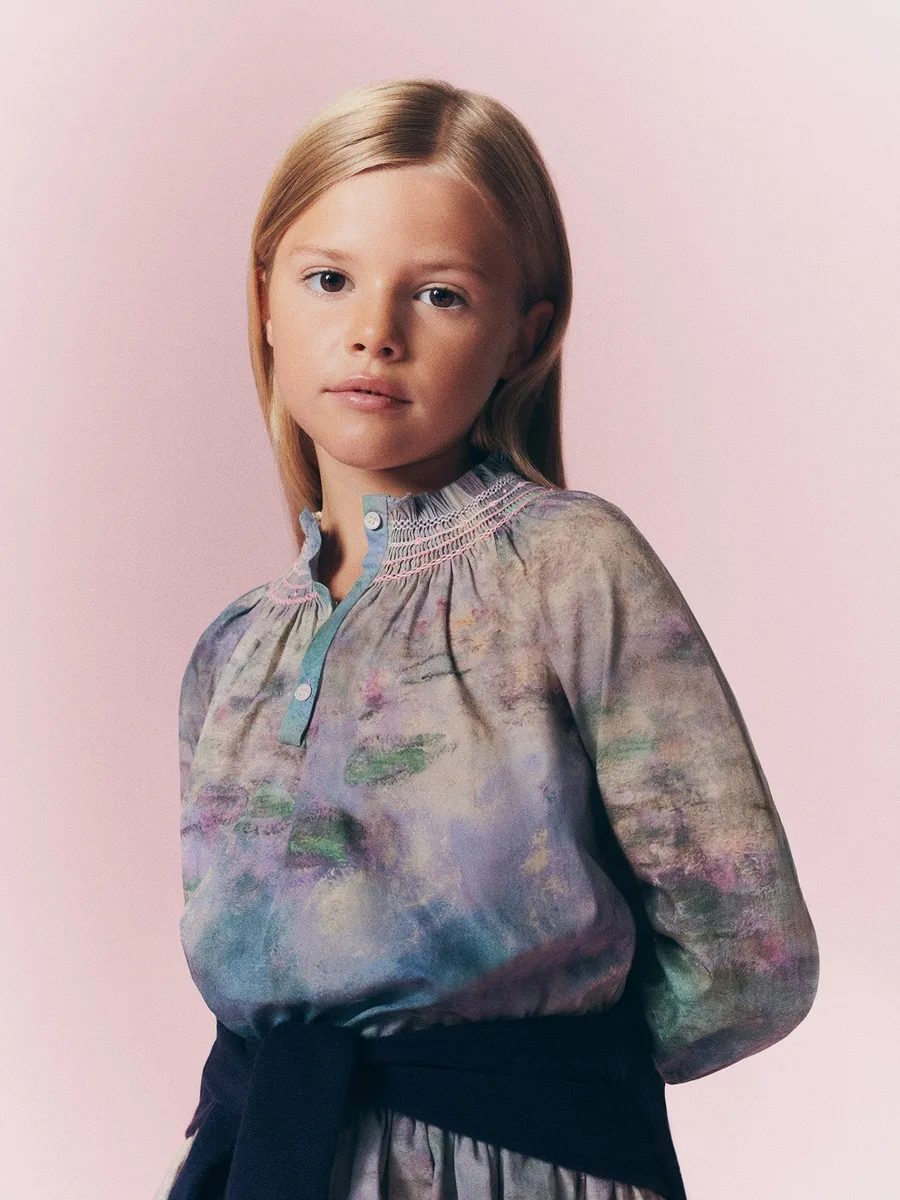 Niña con la blusa de nido de abeja de Bonpoint x MoMA con estampado de nenúfares