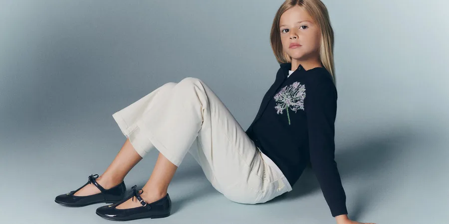 Niña con una chaqueta de punto azul marino de Bonpoint x MoMA con motivo floral