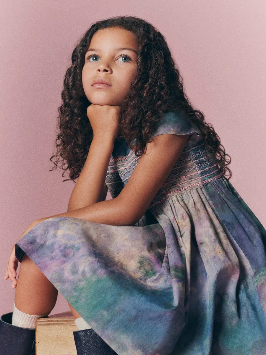 Niña con el vestido de nido de abeja de Bonpoint x MoMA con estampado de nenúfares