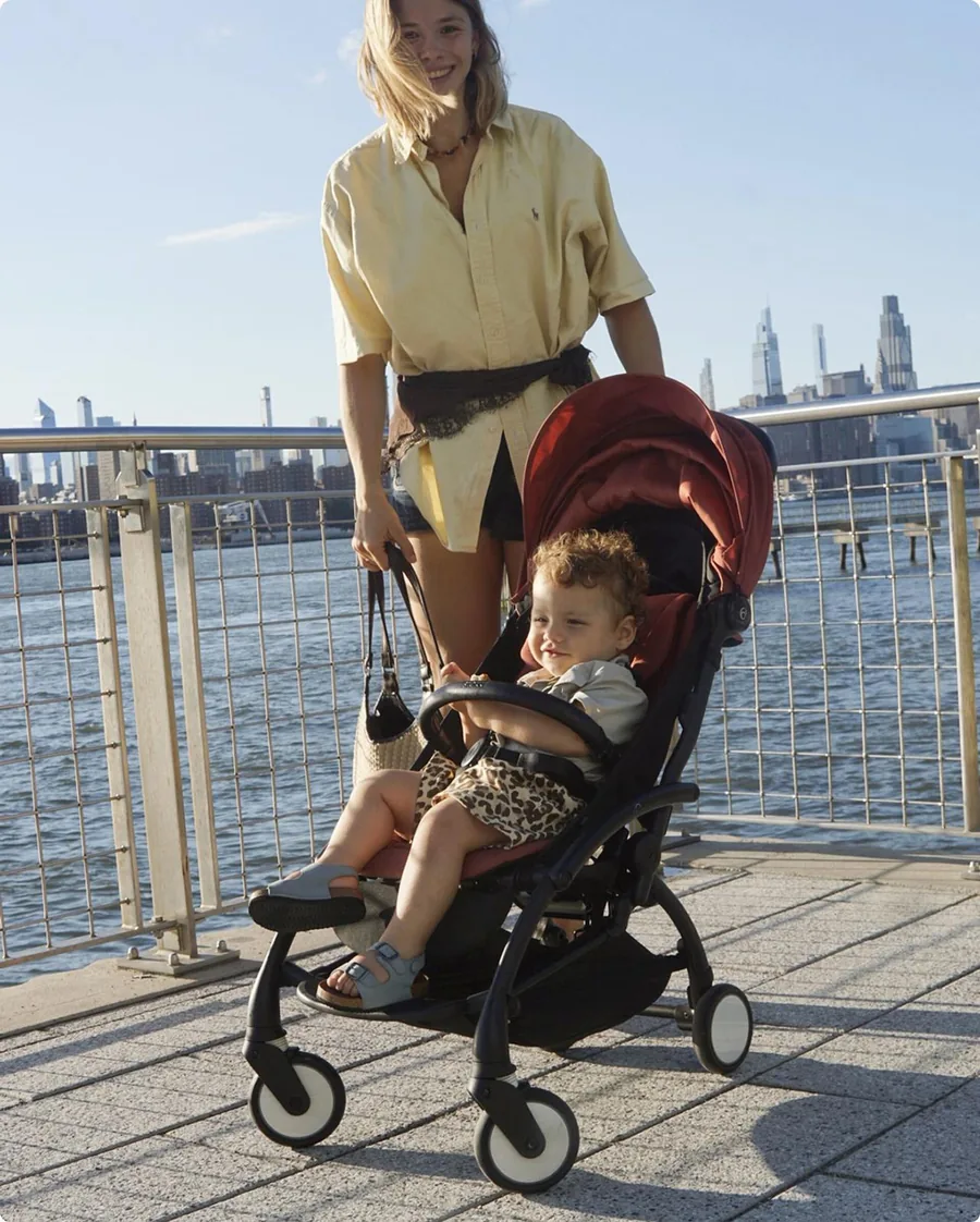 Niño en el Stokke YOYO⁵ en un paseo marítimo
