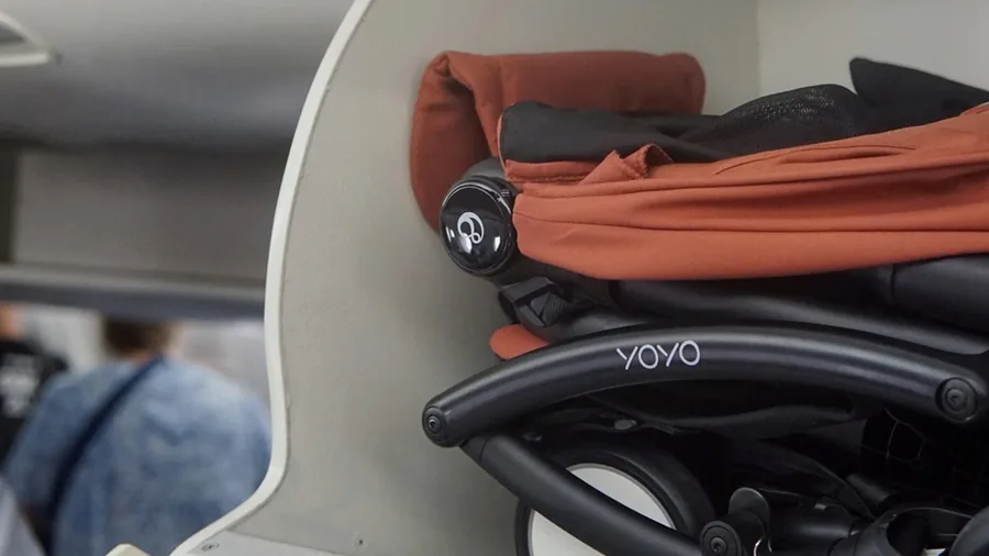 Stokke YOYO⁵ plegado en el compartimento superior de un avión